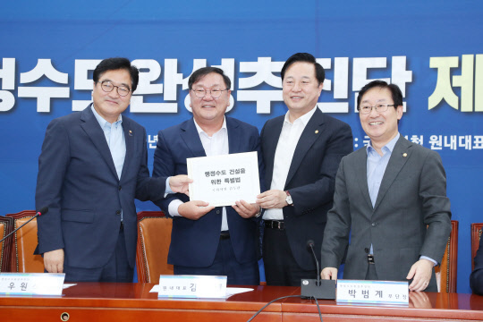 김태년(왼쪽 두번째) 더불어민주당 원내대표가 27일 오후 서울 영등포구 국회에서 열린 행정수도 완성추진단 1차 회의에서 김두관(세번째) 의원에게 행정수도 건설을 위한 특별법을 전달받고 있다.    연합뉴스